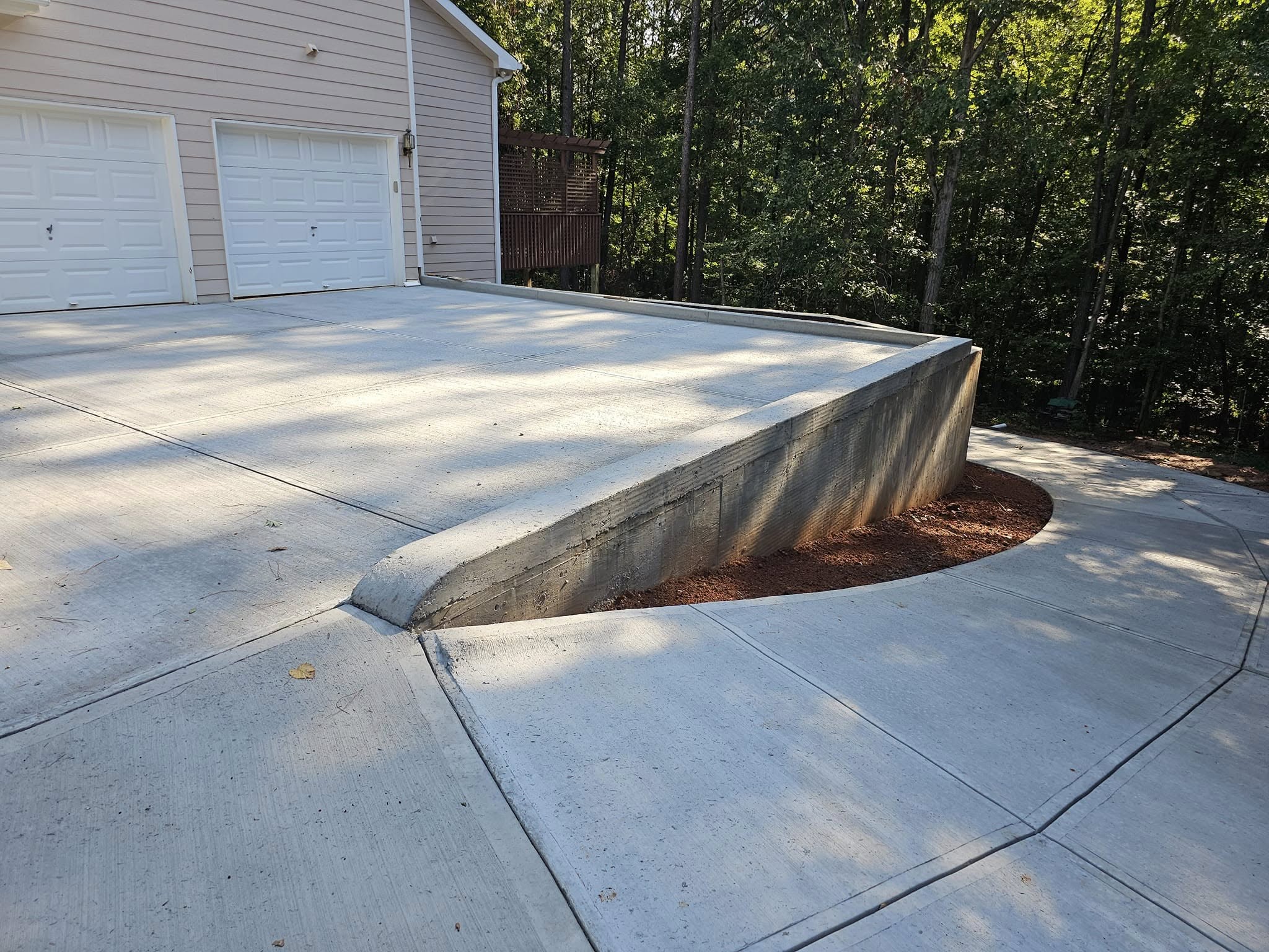 After Driveway Repour with Structural Retaining Wall – Acworth