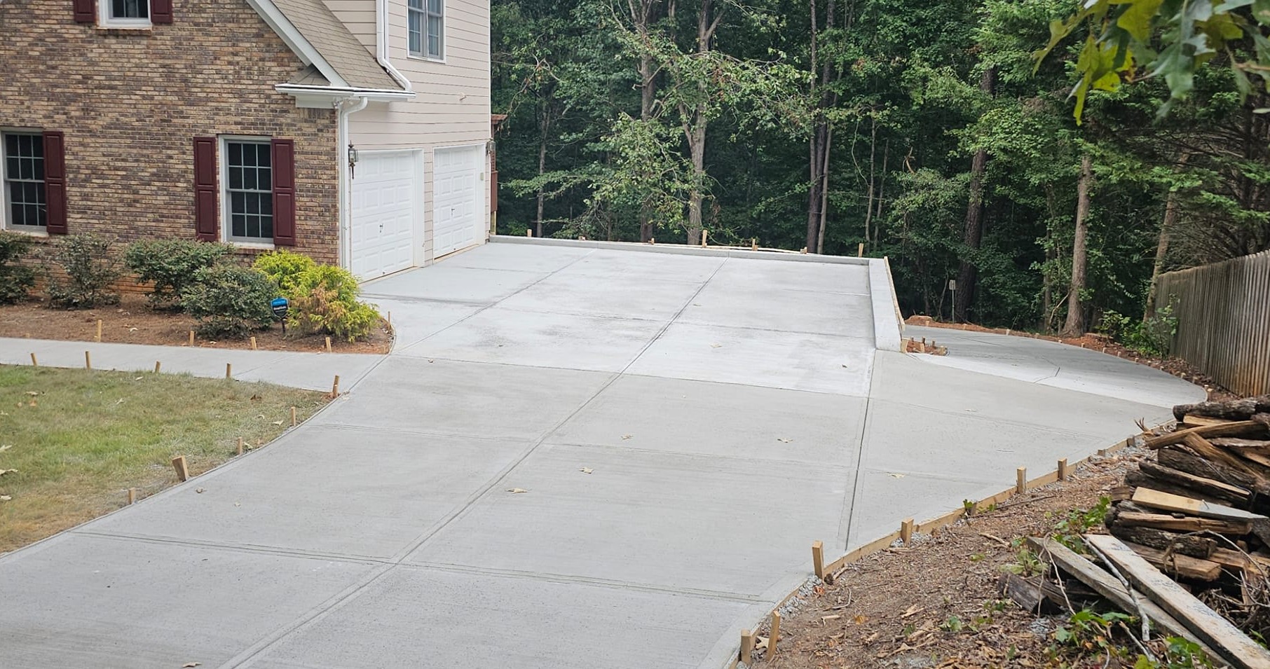 After Driveway Repour with Structural Retaining Wall – Acworth